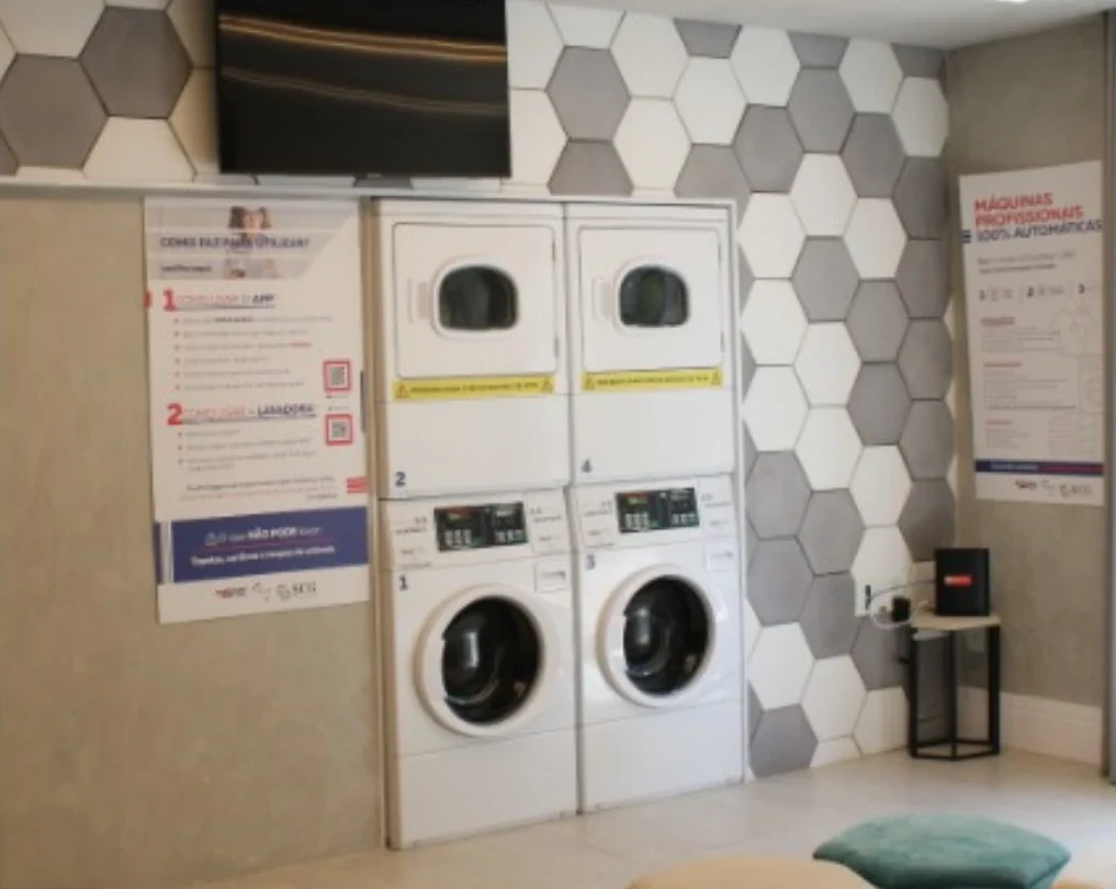 Area de lavanderia compartilhada dentro de um condominio, com maquinas profissionais